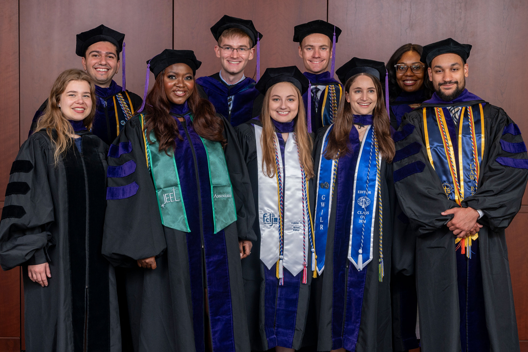 Group of GW Law graduates posing for a photo in their regalia.